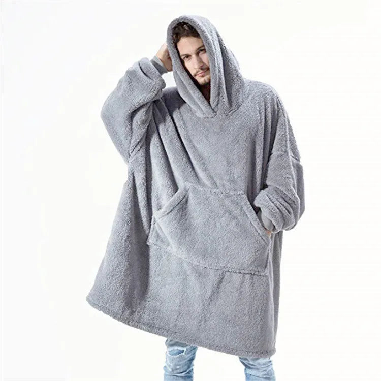 Person wearing a gray fleece poncho with hood on a white background
