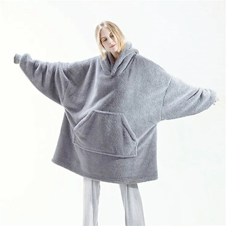 Person wearing a gray oversized hoodie on a white background