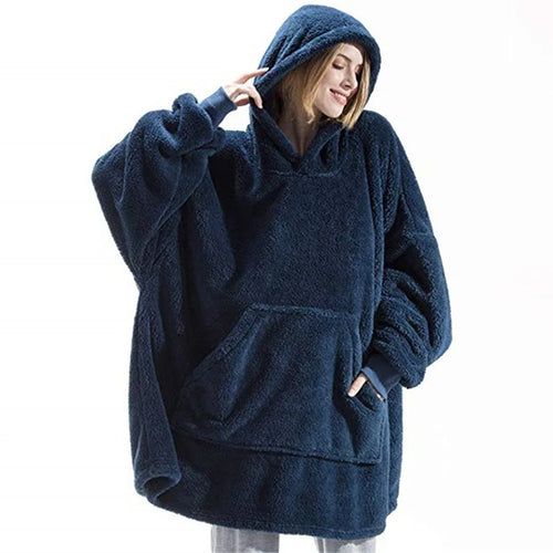 Person wearing a blue fleece poncho with a hood on a white background